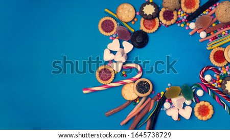 candy background, assortment of colorful candy, mixed unhealthy candies on blue background, unhealthy sugar candies with copy space