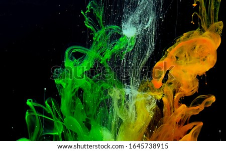 Colored watercolor ink in water on a black background. Cosmic magic background. Digital strings matrix. Abstract background. Cool trending screensaver.