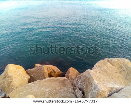 View on the sea at the shore. Huge stones and sea background