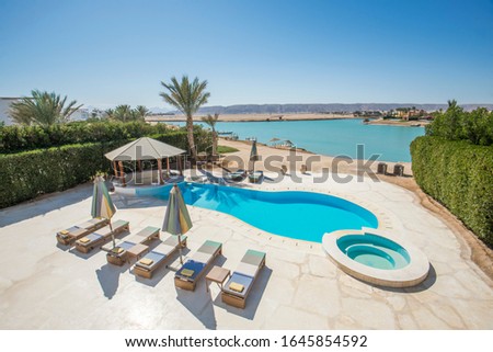 Luxury villa show home in tropical summer holiday resort with swimming pool and bar