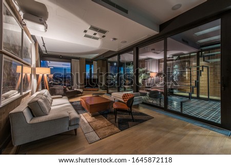 Interior of a living room in a luxury penthouse apartment in the evening Royalty-Free Stock Photo #1645872118