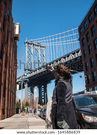 Young woman taking picture at Manhattan bridge from road on sunny winter day. New York, USA. NY_30_362