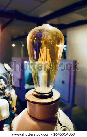 The beautiful light bulb in the middle of the picture, the room background. Light bulb at the restaurant. Lamp for decoration.