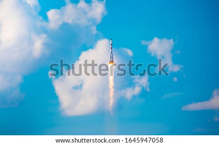 A real rocket in flight, a launch vehicle from a spaceport. Take-off rocket in the sky against the background of clouds. Launch concept, the power of science and technology. Modern technology.