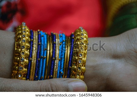 Side view of girl wearing colorful glass bangles