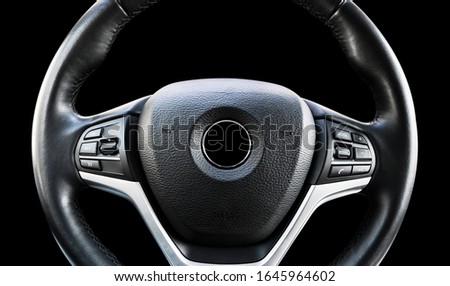 Modern car interior. Steering wheel with media phone control buttons isolated on black background. Car interior details. Car detailing. Steering wheel isolated on black background