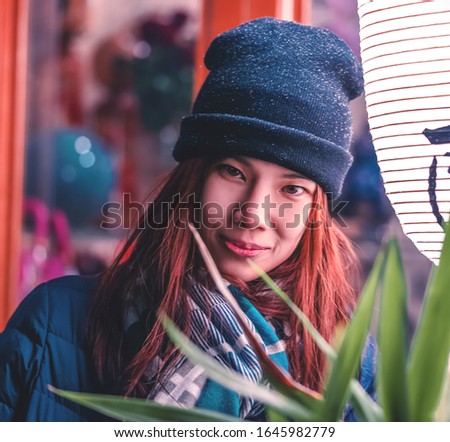 Beautiful woman is taking a picture beside japanese lanterns light in traditional Japanese building