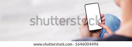 Over The Shoulder View Of The Blank Screen On A Smartphone