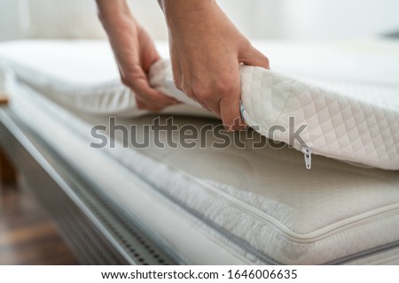 Mattress Topper Being Laid On Top Of The Bed Royalty-Free Stock Photo #1646006635