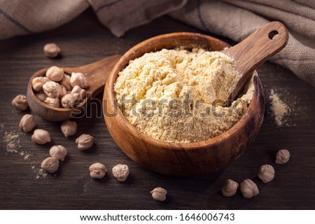 Chickpea flour in a wooden bowl  isolated on a white background
