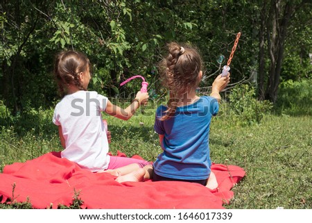 children have a rest in the summer in the forest and blow bubbles