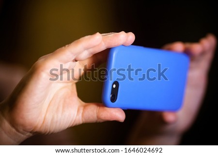 Blue Smartphone in hands: a man takes a photo on a smartphone
