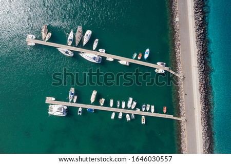Aerial view of amazing boats. Minimalistic landscape with boats and sea in marina bay. Top view from drone of harbor with yacht and motorboat. Morro Jable, Fuerteventura, Canary islands, Spain