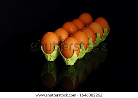 Chicken eggs in a cardboard container for the storage and transportation of chicken eggs isolated on black background