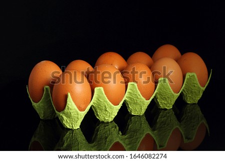 Chicken eggs in a cardboard container for the storage and transportation of chicken eggs isolated on black background