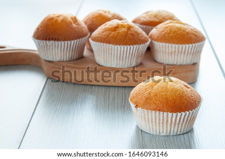 Fresh homemade delicious muffins are taken out of the oven and they cool on the kitchen table. Sweet dessert.