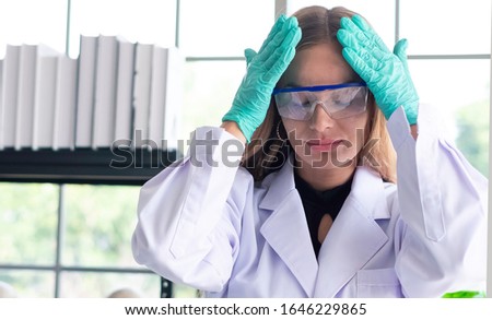 Stressed scientist got headache with her lab results in science lab. Failed science researcher having problem analyzing medicine related innovation. Stressed scientist  & medical researcher concept.  