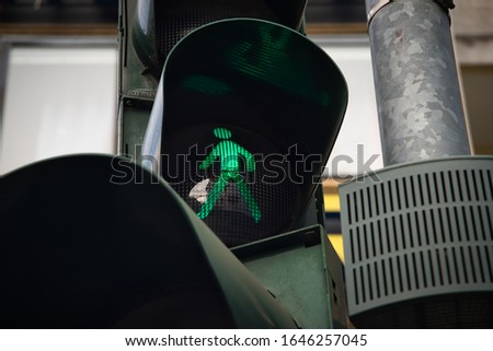 Street crossing signal light with green man for traffic