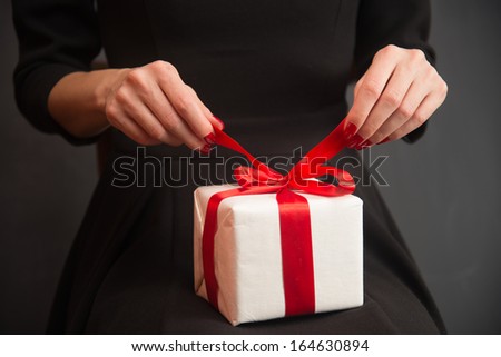 Unrecognizable woman is opening a gift box