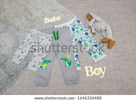 pants on a newborn baby boy. bodysuit on gray background with place for text