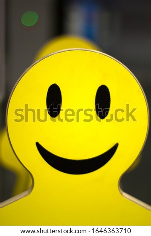 plywood tablet in the form of a silhouette of a smiling face man. Bright yello face photo taken at the airport