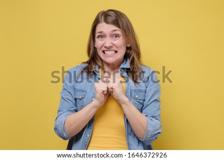 Awkward caucasian woman feeling embarrassed, confused nervous before exam isolated on yellow studio background. Omg I made a terrible mistake.