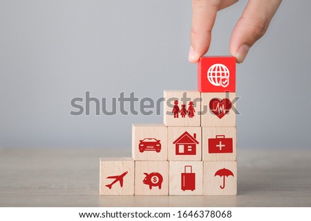 Hand arranging wood block stacking with icon insurance: car,