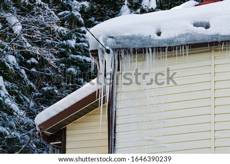 Large icicles under the roof of the house.