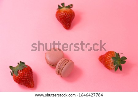 View of 2 macarons and 3 strawberries.