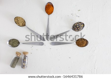 Spoons with spices and herbs from around the world. Flat lay cooking and baking concept picture on light background