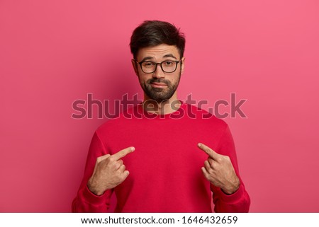 I can handle it. Assertive determined man with beard points at himeself, feels proud and brags about own achievements, proposes own help, wears red sweater, eyewear, stands against pink background Royalty-Free Stock Photo #1646432659
