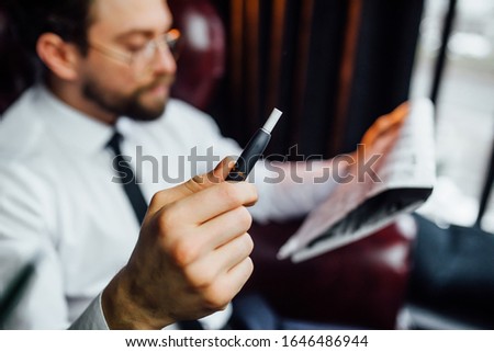 Cropped image, business man resting on armchair in luxury room, man smoking cigar in his house.