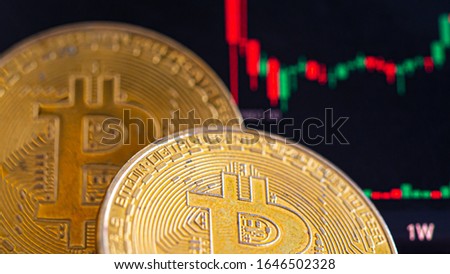 ฺBitcoin coin place on floor, the back is the screen Candlestick chart pattern. Concept Trading and investing in cryptocurrencies.