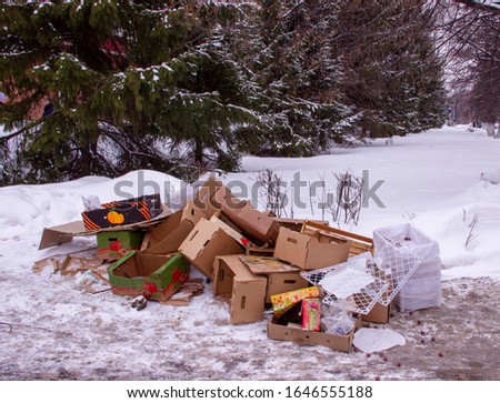 Cardboard boxs with trash in the snow, pollution trash in winter. The concept of the problem of ecology, environmental pollution by garbage. Footprints in the snow. Image. Royalty-Free Stock Photo #1646555188