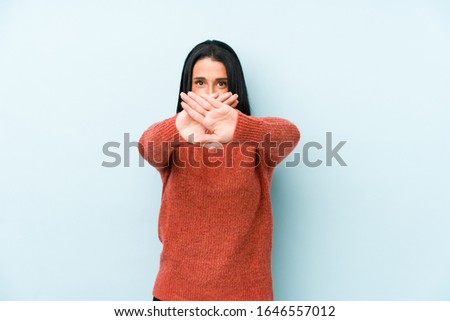 Young caucasian woman isolated on a blue background doing a denial gesture