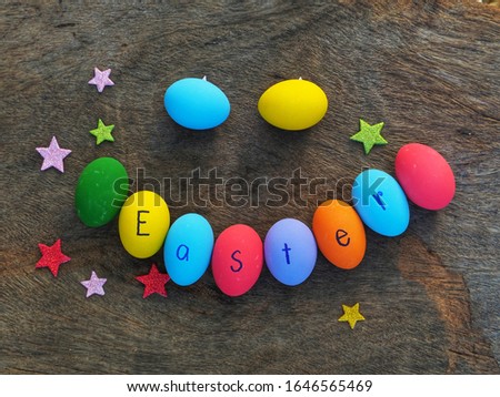 Colorful Easter eggs smile concept and paper star on the wooden background.
