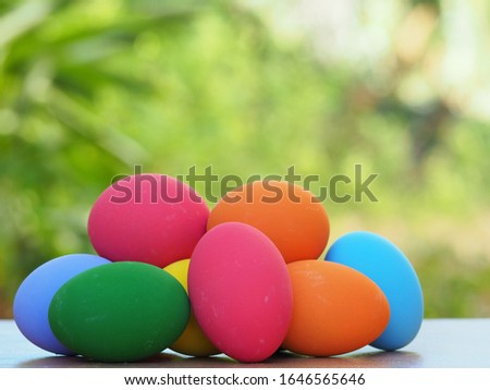 Colorful Easter eggs on the wood table and green background.