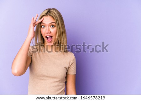 Young blonde caucasian woman isolated shouts loud, keeps eyes opened and hands tense.