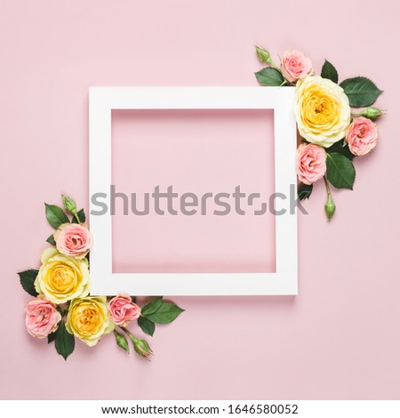 White paper Frame of beautiful roses on pink background. Minimal holiday concept with copy space. Woman day, Valentines day layout.