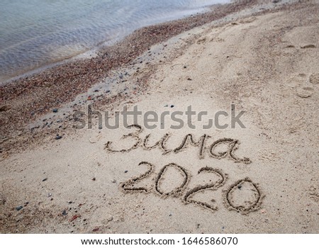 Signed words winter 2020 in Russian on sand beach
