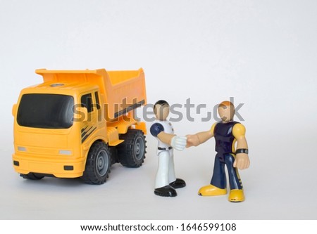 Toy men shake hands near the truck