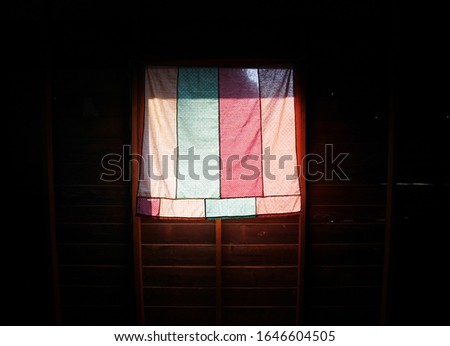 Sunlight panning the curtain pantone window on an old wooden house in a rural area.