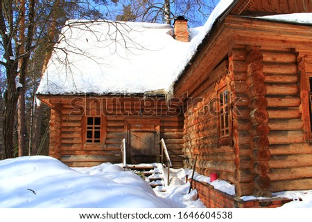 Old wooden house in the snow in winter.
