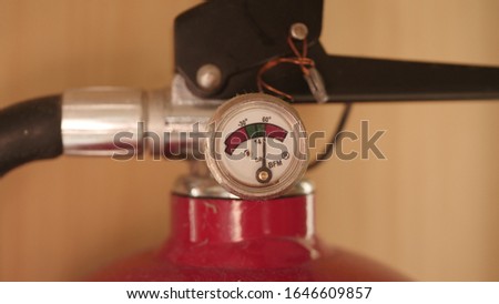 Red fire extinguisher in the apartment on the wall