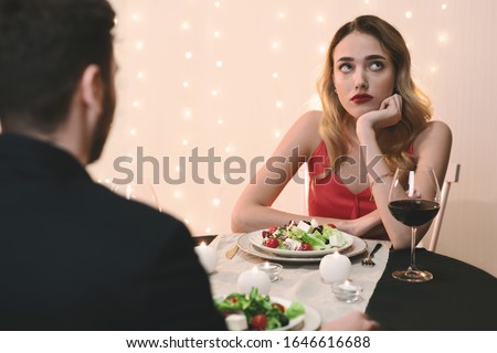 Unsuccessful Date. Young woman feeling bored at dinner in restaurant, looking away with disappointed face expression, selective focus Royalty-Free Stock Photo #1646616688