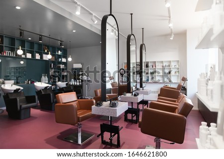 Stylish beauty salon interior. Hairdresser and makeup artist workplaces in one room, creative mirrors Royalty-Free Stock Photo #1646621800