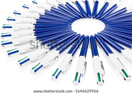 4-colour plastic ballpoint pens with a click mechanism. Isolated pens lying on the white surface in na circle. design for posters, brochures or vouchers.