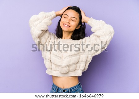 Young chinese  woman isolated on a purple background laughs joyfully keeping hands on head. Happiness concept.