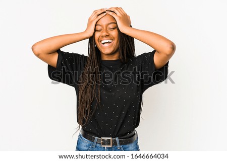Young african american woman isolated on white background laughs joyfully keeping hands on head. Happiness concept.