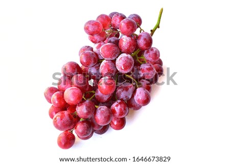 A large bunch of fresh red grapes placed on a white background